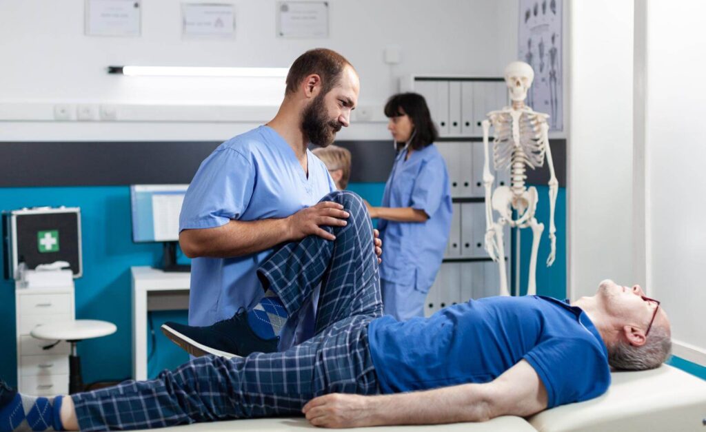 An Osteopath providing knee therapy to an elderly patient.