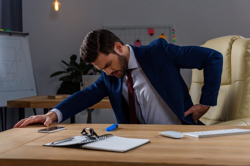 vistacreate 177916556 stock photo young businessman sitting chair having pain back