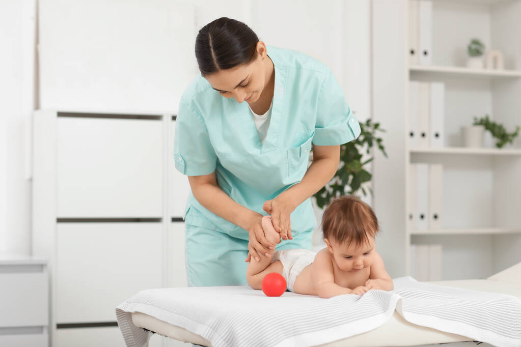 cute little baby getting feet massage ball happy professional therapist
