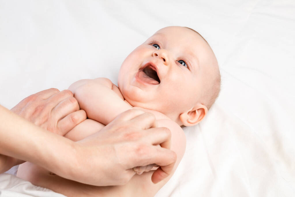 happy month baby boy receiving massage therapy pediatric clinic manual
